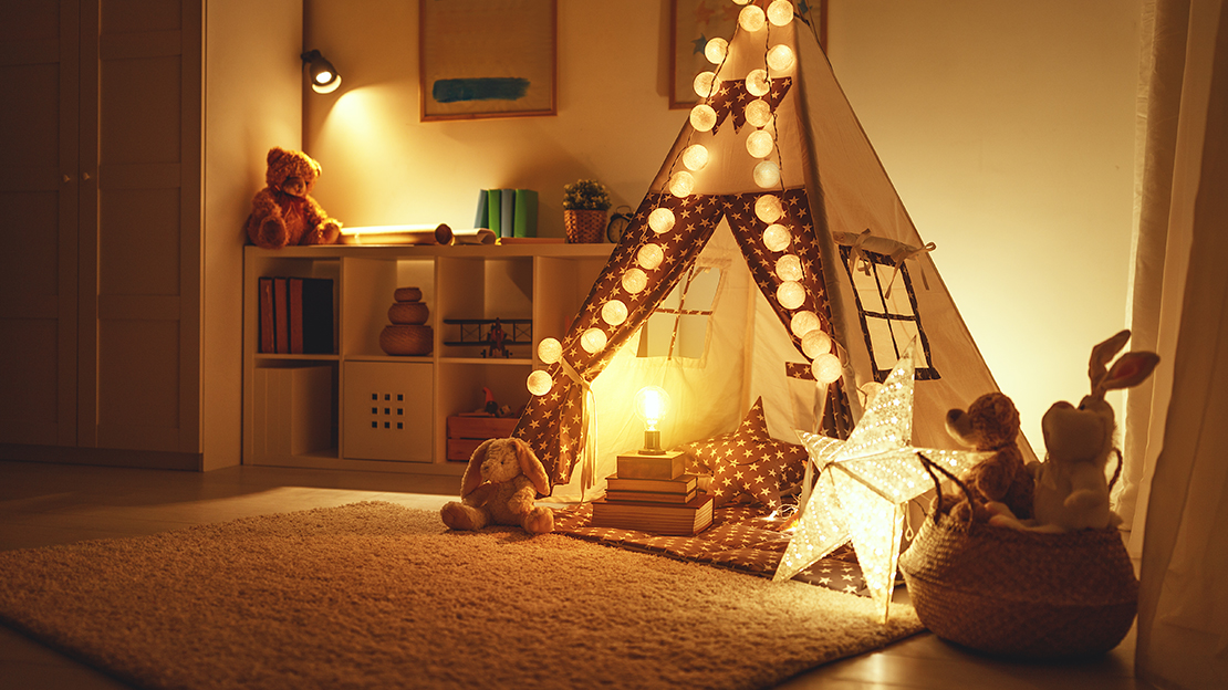 Bild på upplyst barnrum med leksaker och tält.