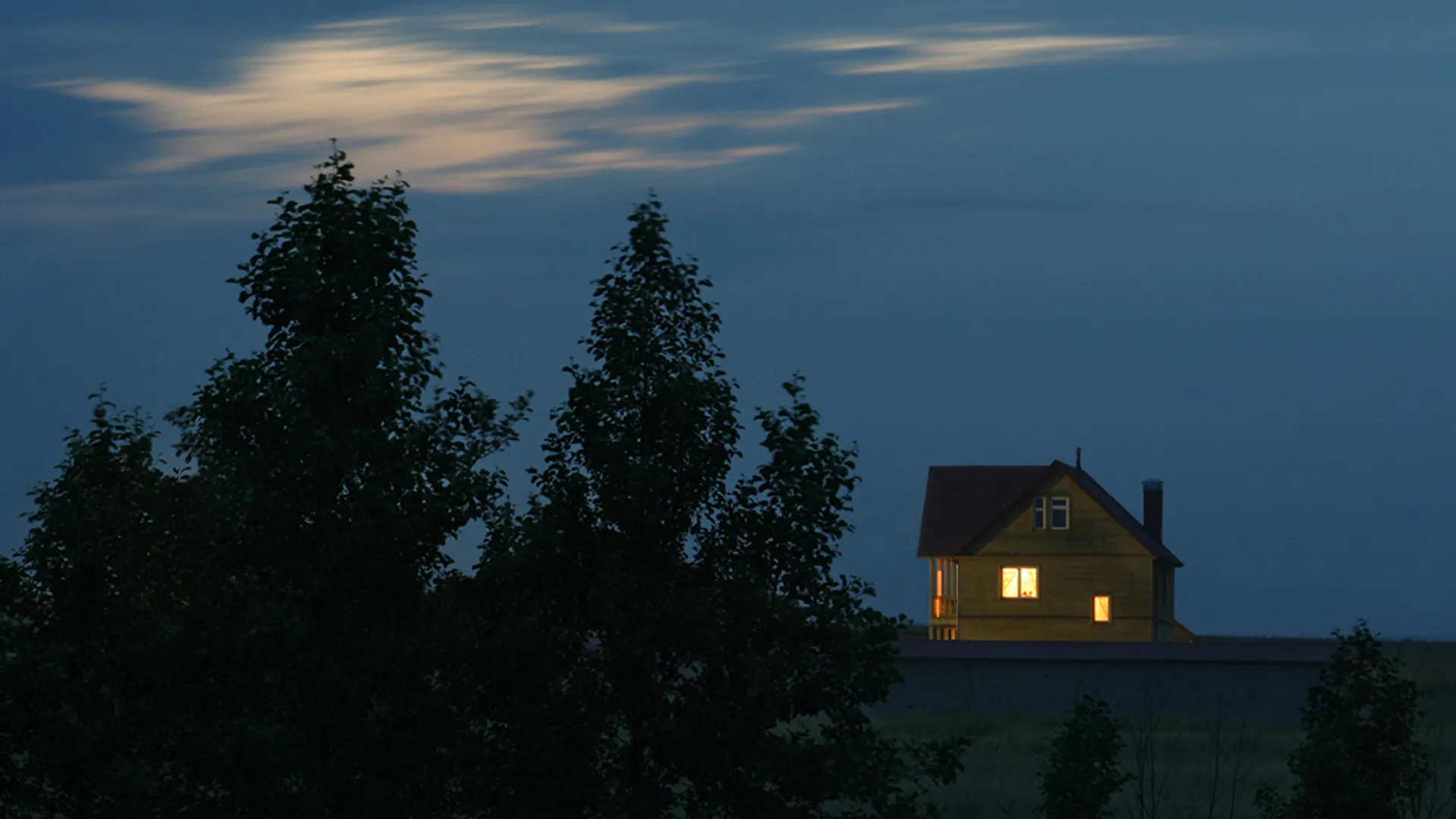Ensam villa med lampor i fönstren på kvällen
