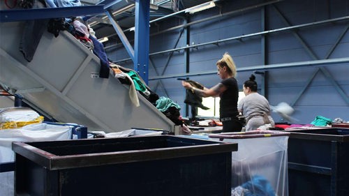 Textilier sorteras i återvinningsanläggning.
