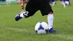 En person tar sats för att sparka på en fotboll.