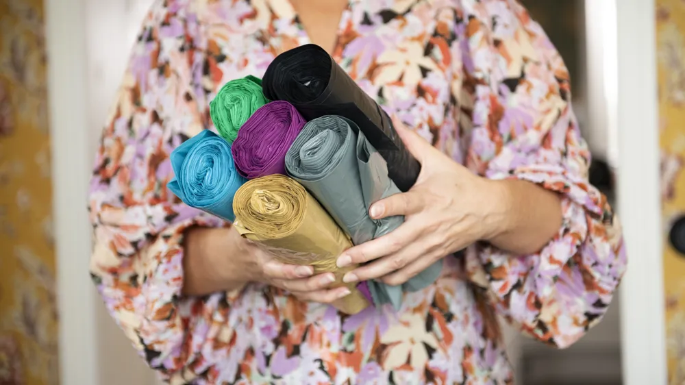 Kvinna som håller i rullar med färgsorteringspåsar.