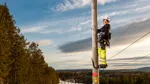 Person arbetare på en kraftledningsstolpe.