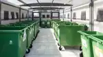 Gröna avfallskärl i ett sorteringshus