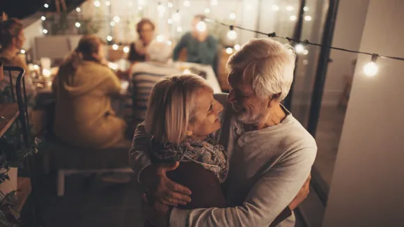 Man och kvinna kramas på en balkong.