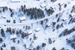 Snötäckt landskap med väg och hus.