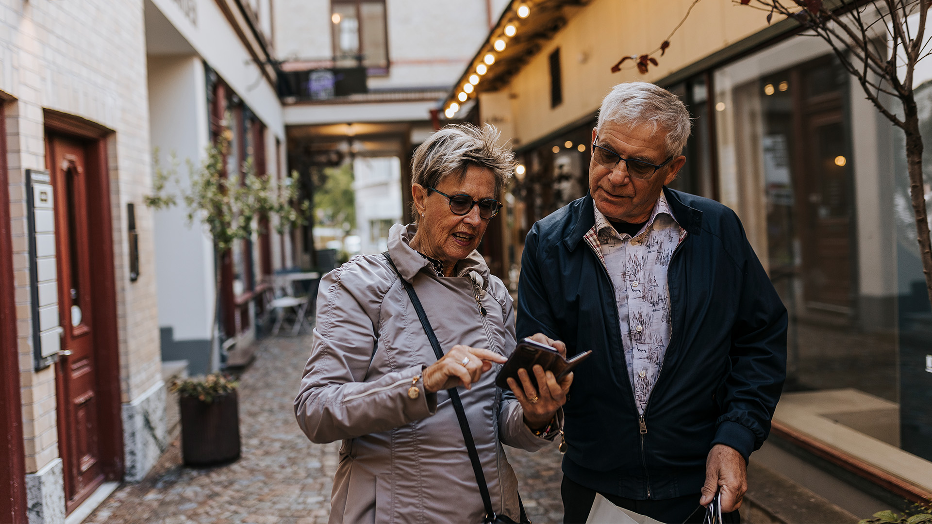 Två personer som står och tittar på en telefon tillsammans