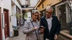 Två personer som står och tittar på en telefon tillsammans