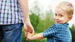 Pojke håller pappas hand