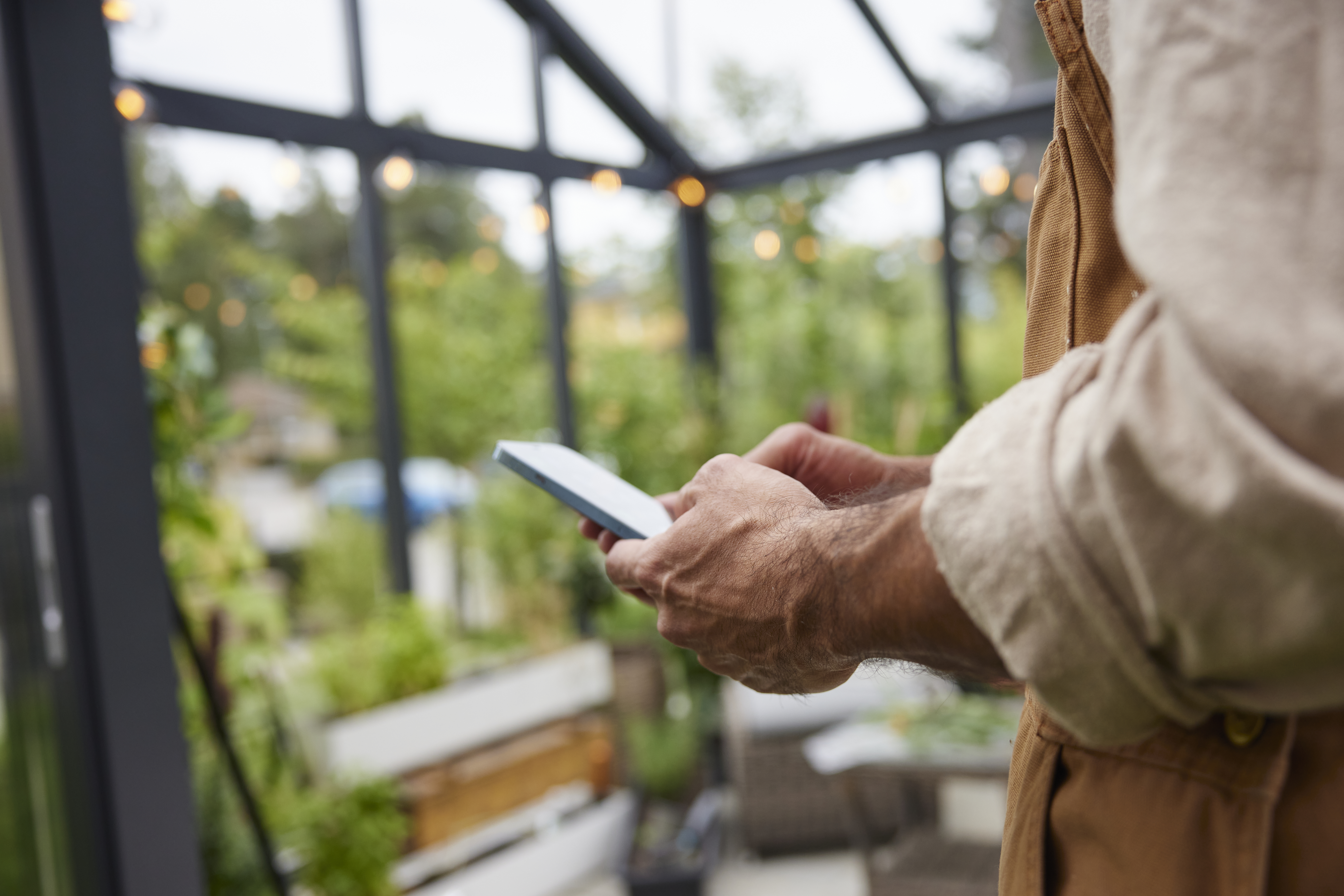 Händer håller i en mobil, närbild.