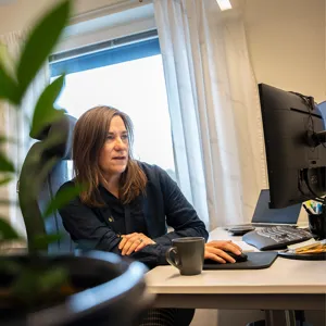 Anna-Åsa framför sin dator när hon arbetar