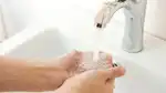 Kupade händer under vattenkran