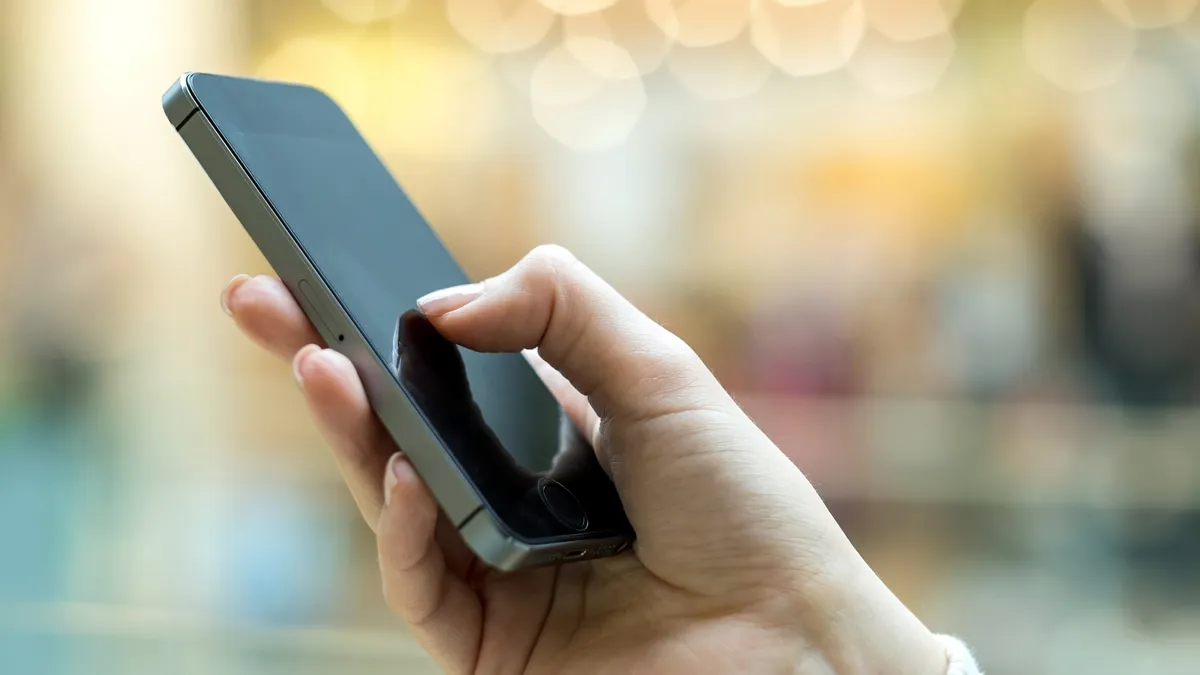 En hand som håller i en mobil.